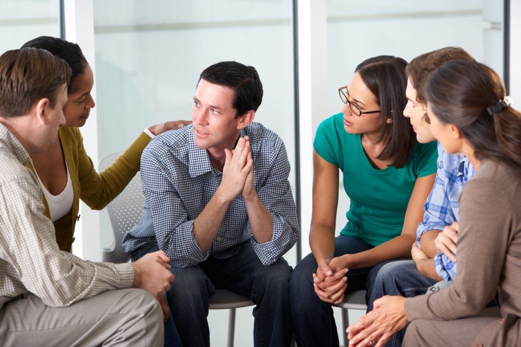 man comforted by his friends