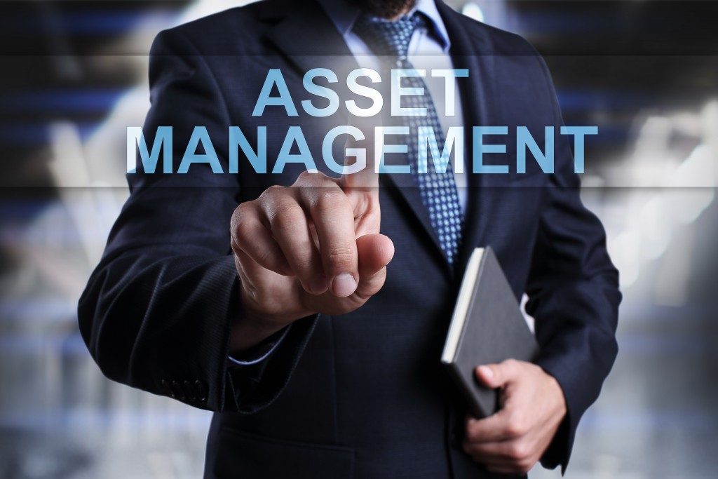 businessman pressing button on touch screen interface and select asset management