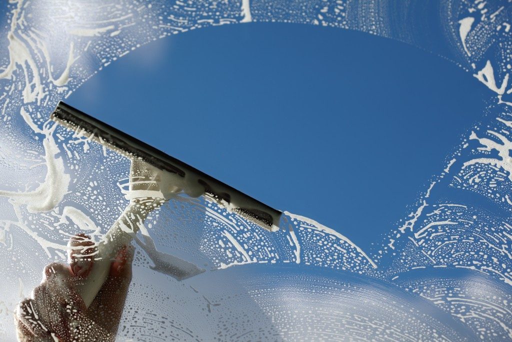 Person cleaning the window using a squeegee